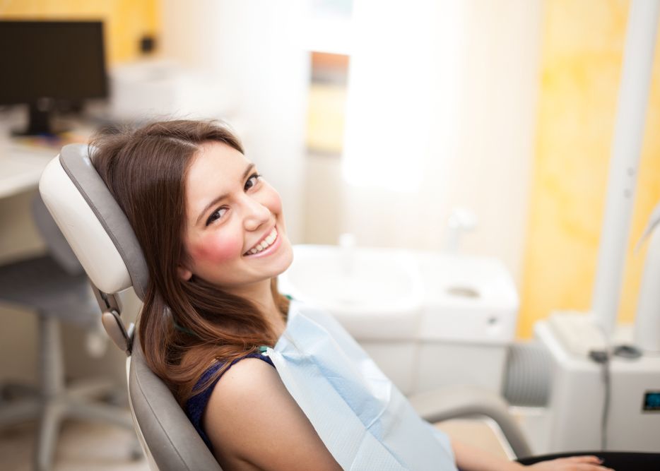 Laughing young woman sitting in exam chair