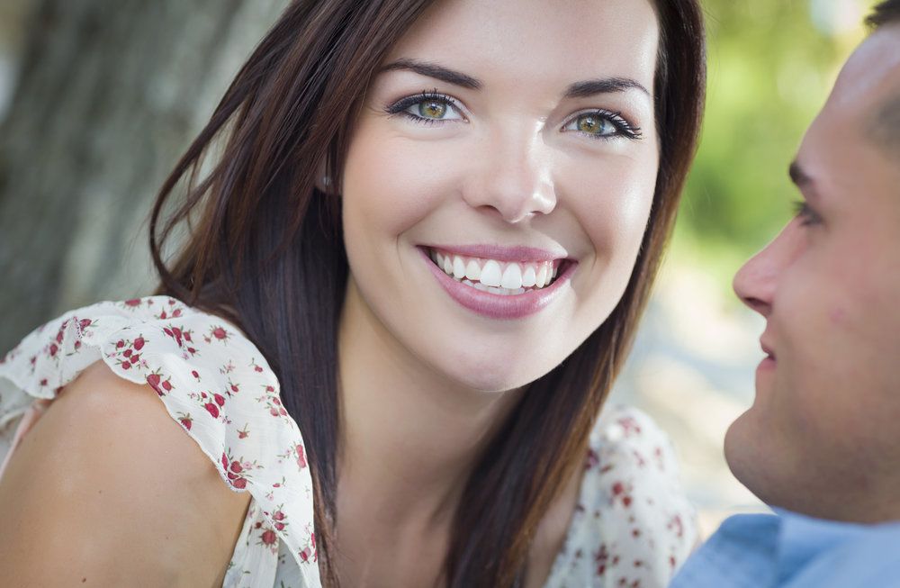 Man looking adoringly at smiling woman in ruffly shirt