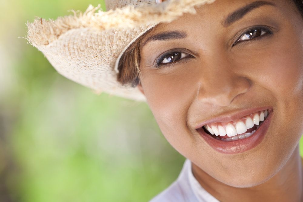 Close up of woman's face wearing straw hat